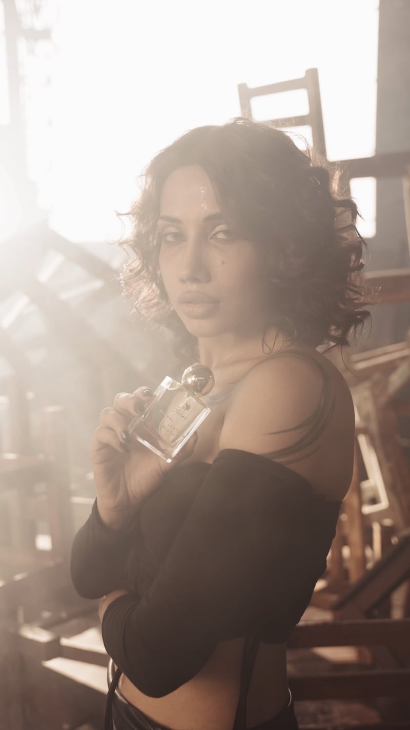 A woman among stacked chairs in warm daylight, a still from the film