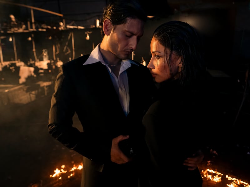 A couple turned towards each other beside the burning ring