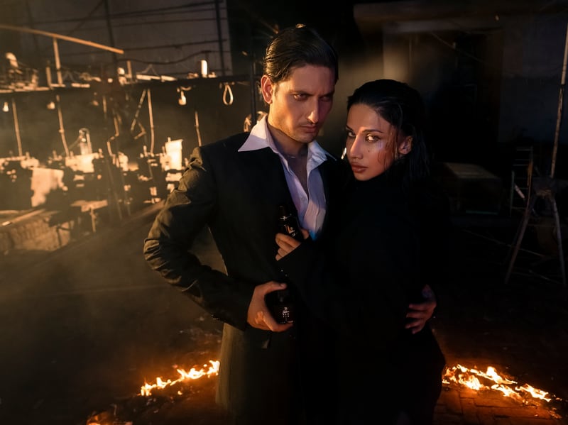 A couple standing close at a ring of fire, the Allure Ice flacon between them