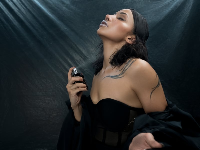 A woman with her head tilted back, the North + Light flacon held to her throat